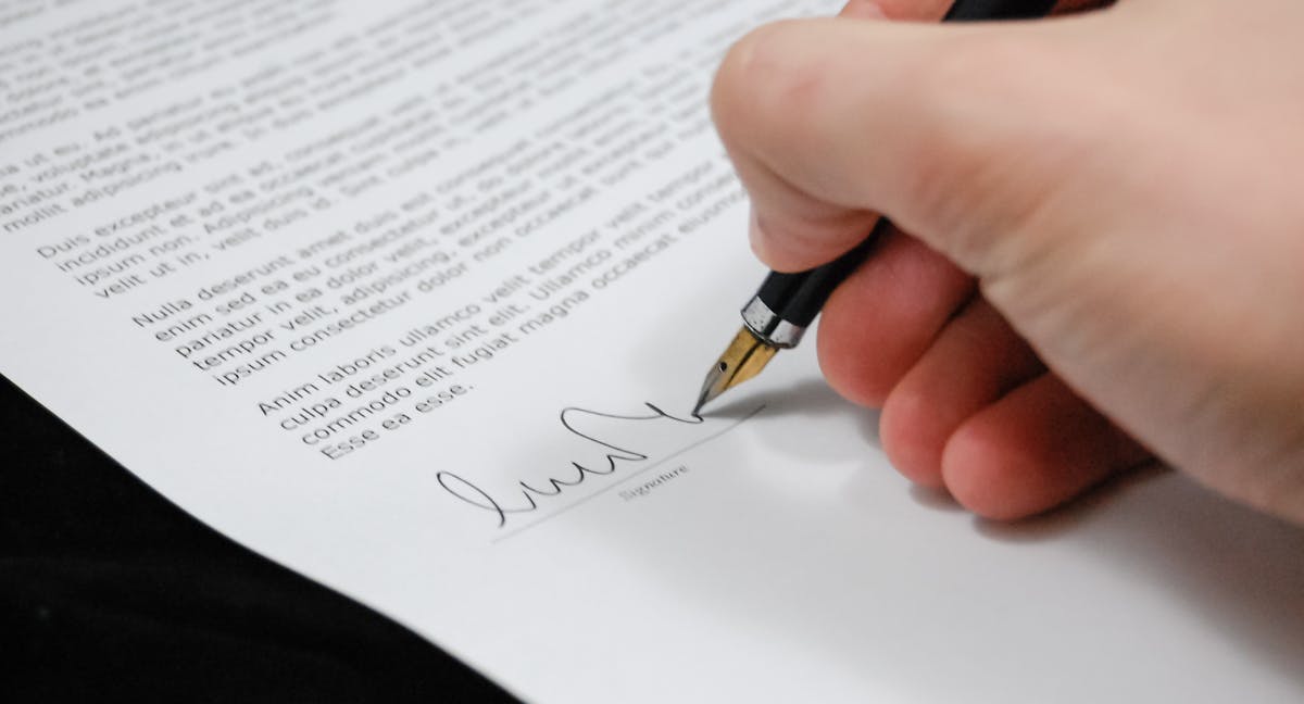 Hand signing legal document with fountain pen - VIES bond power of attorney